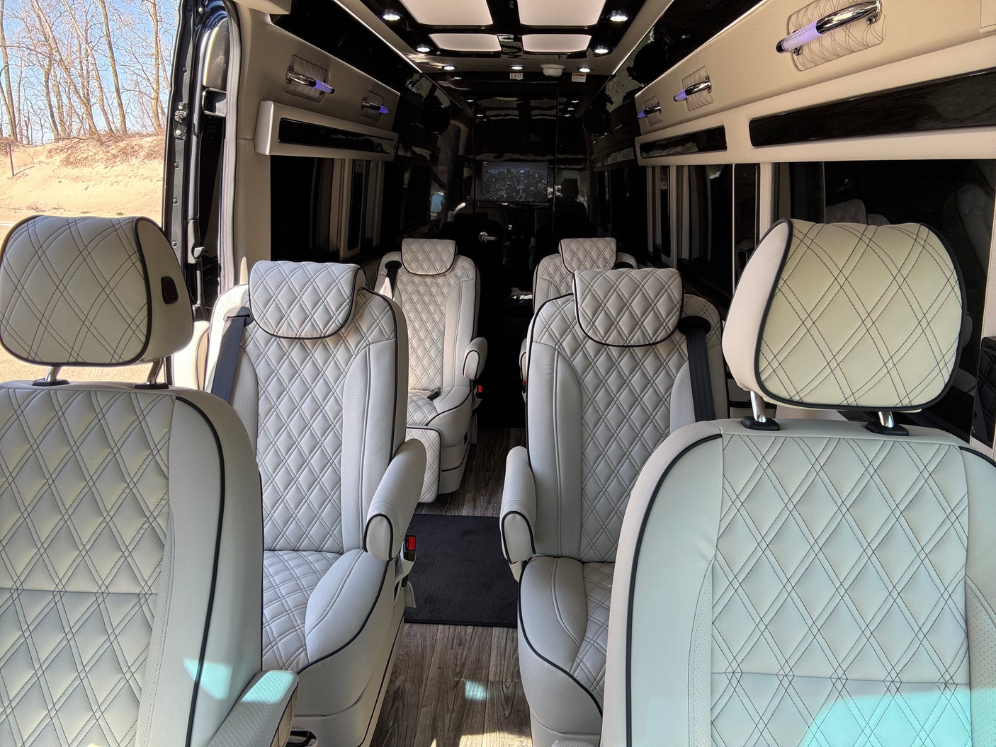 Premium RV rental interior showcasing diamond-stitched leather captain's chairs and spacious private cabin design.