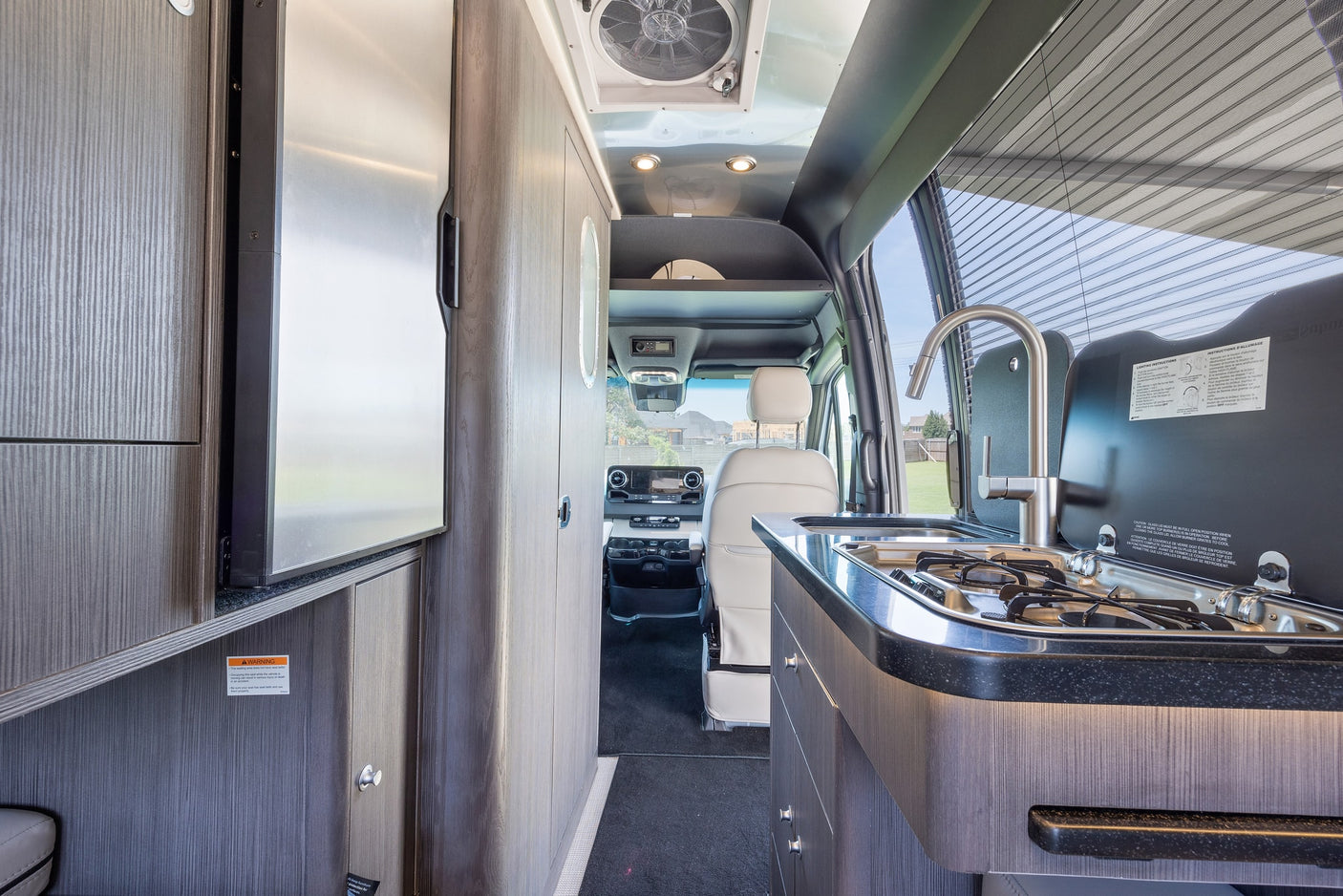 with an awning extended.|Silver RV rental camper van with all doors open and awning extended