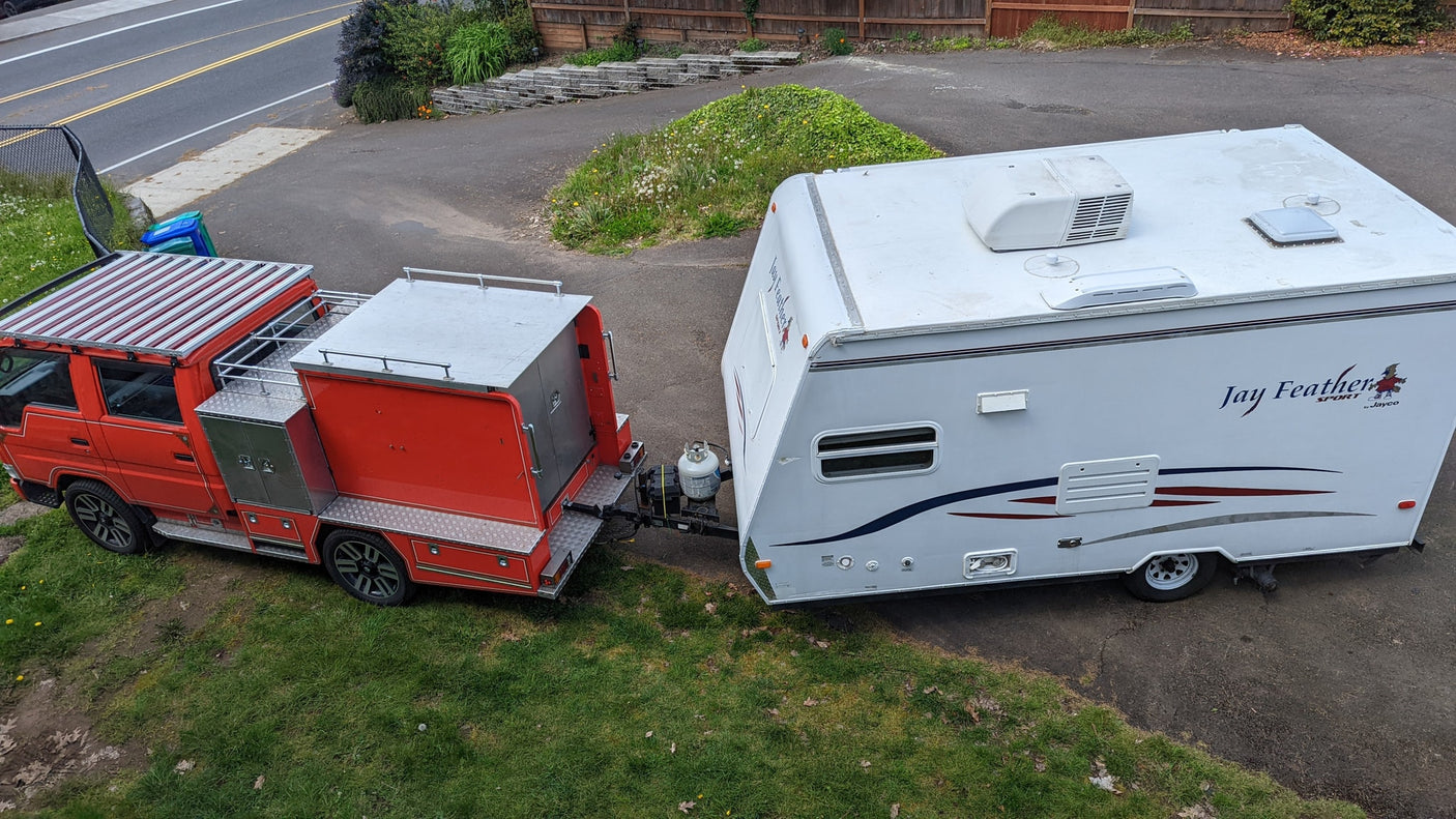 Overhead view: a custom red truck towing a white Jayco travel trailer, perfect for your next RV rental adventure.