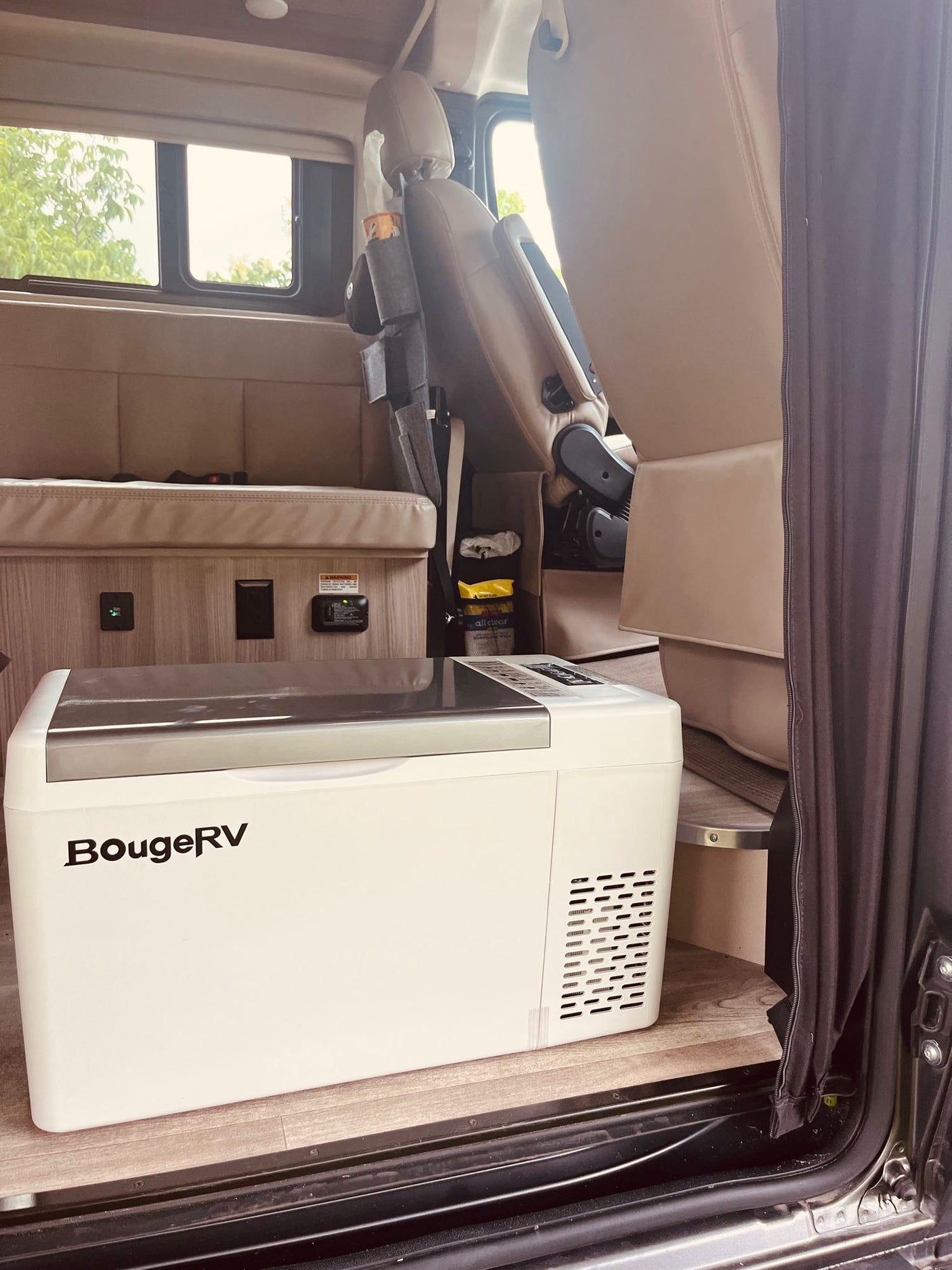 RV rental interior featuring a BougeRV portable fridge, cozy seating, and essential power outlets for travel adventures.