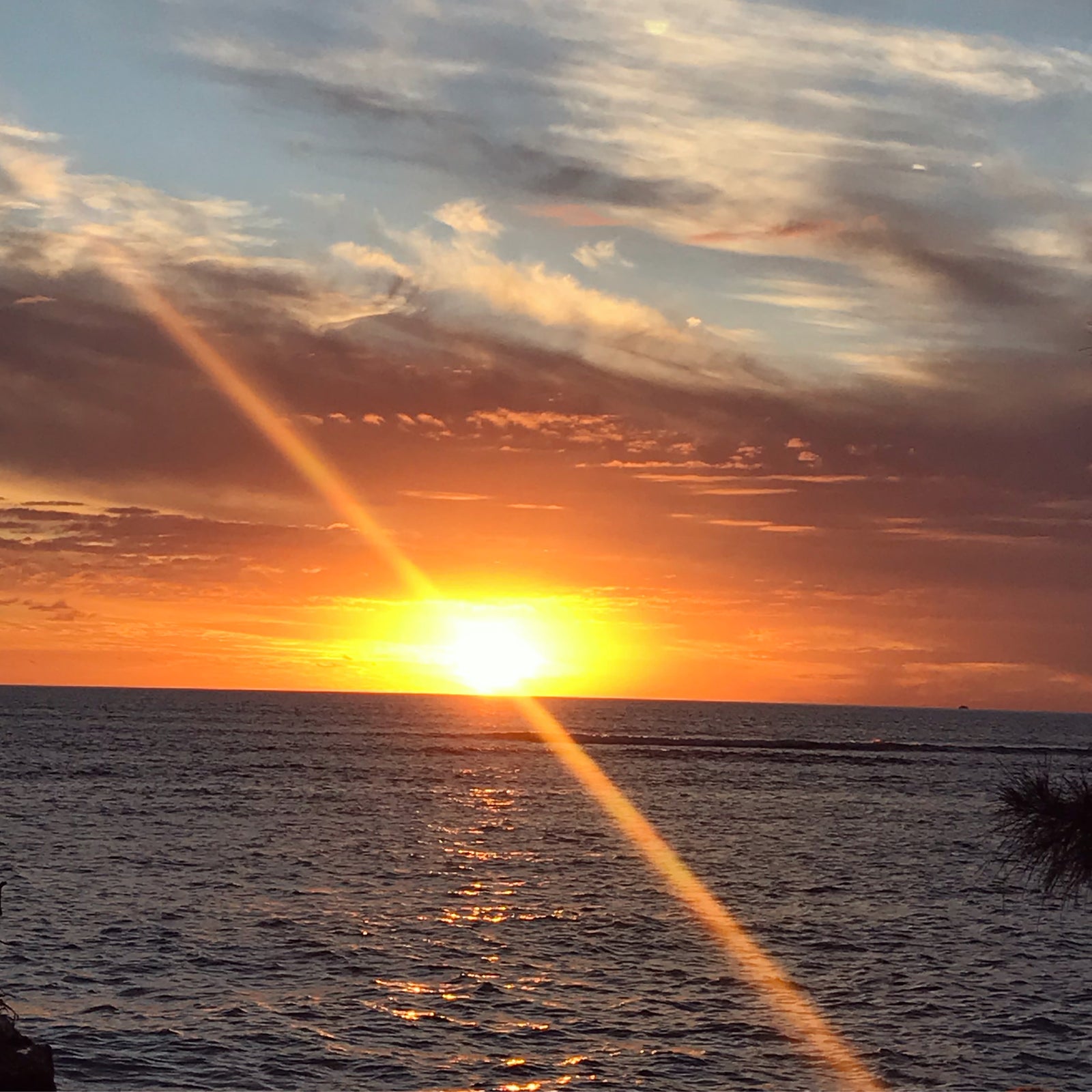Stunning ocean sunset with sunbeams, perfect for an RV rental adventure. Experience scenic travel.