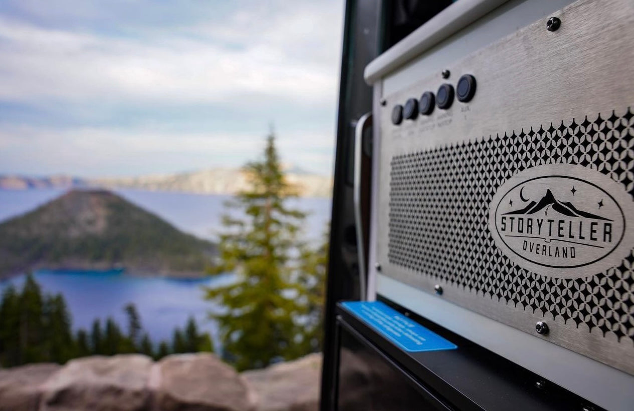 Storyteller Overland RV rental panel with a stunning view of Crater Lake and Wizard Island. Perfect for adventure travel.