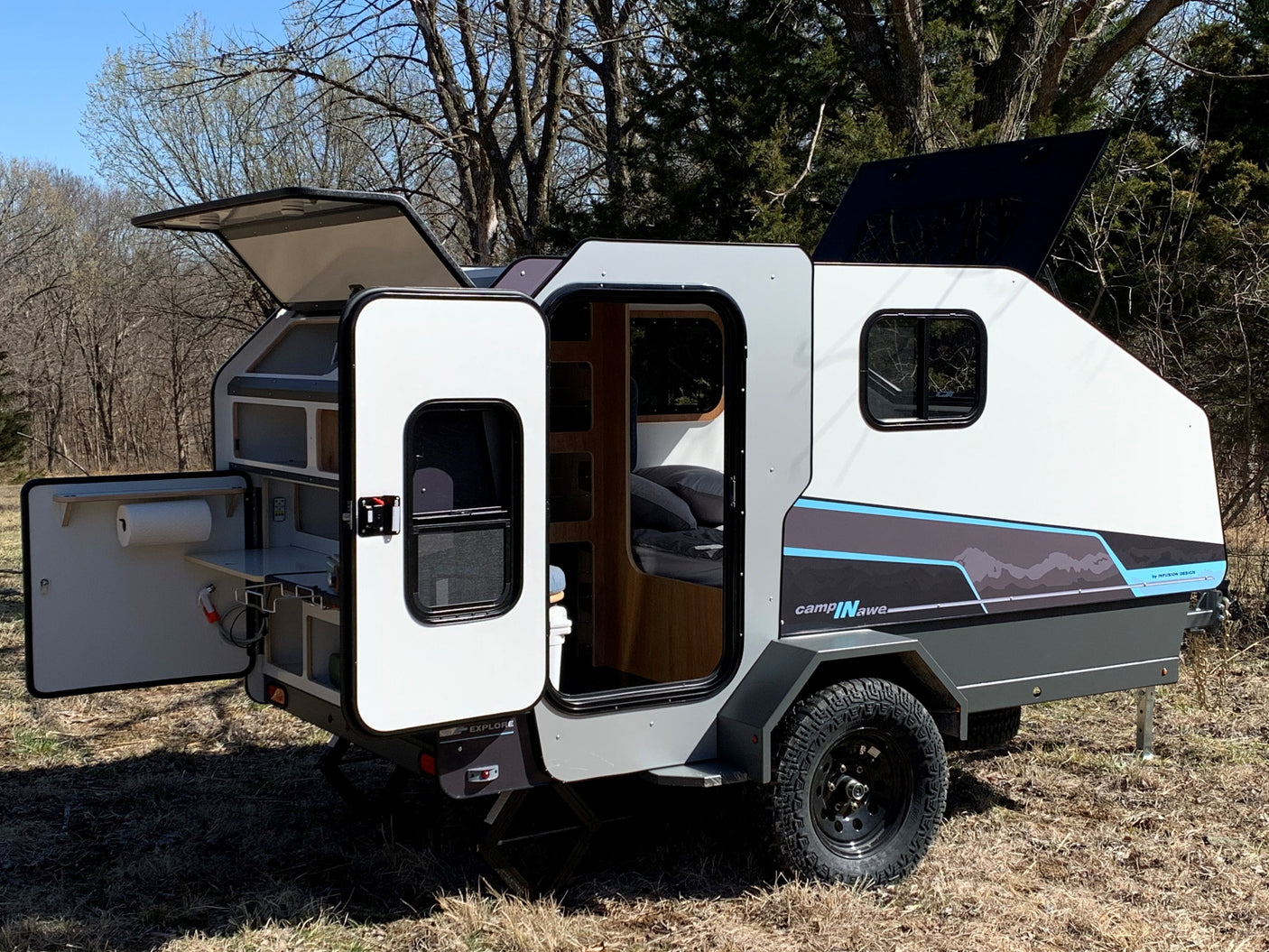 A sleek, compact rv rental camper with an outdoor kitchen & interior bed, ideal for off-grid adventures in nature.