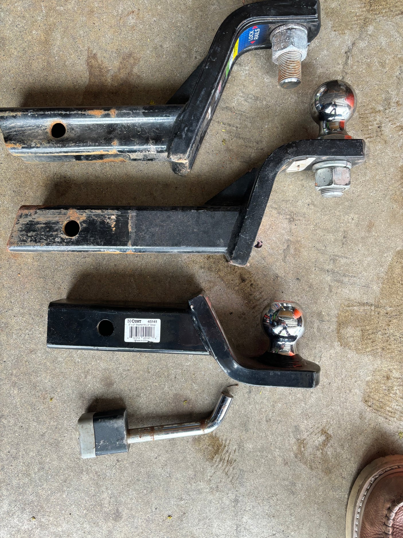 Towing essentials for your RV rental: multiple trailer hitch ball mounts & a hitch pin ready for use.