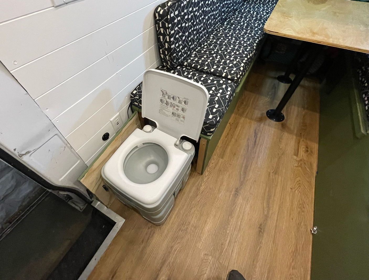 and cabinets. Cozy seating and bright LED lighting create a comfortable mobile living space.|Inside an RV rental: a modern van conversion with geometric pattern bench seating