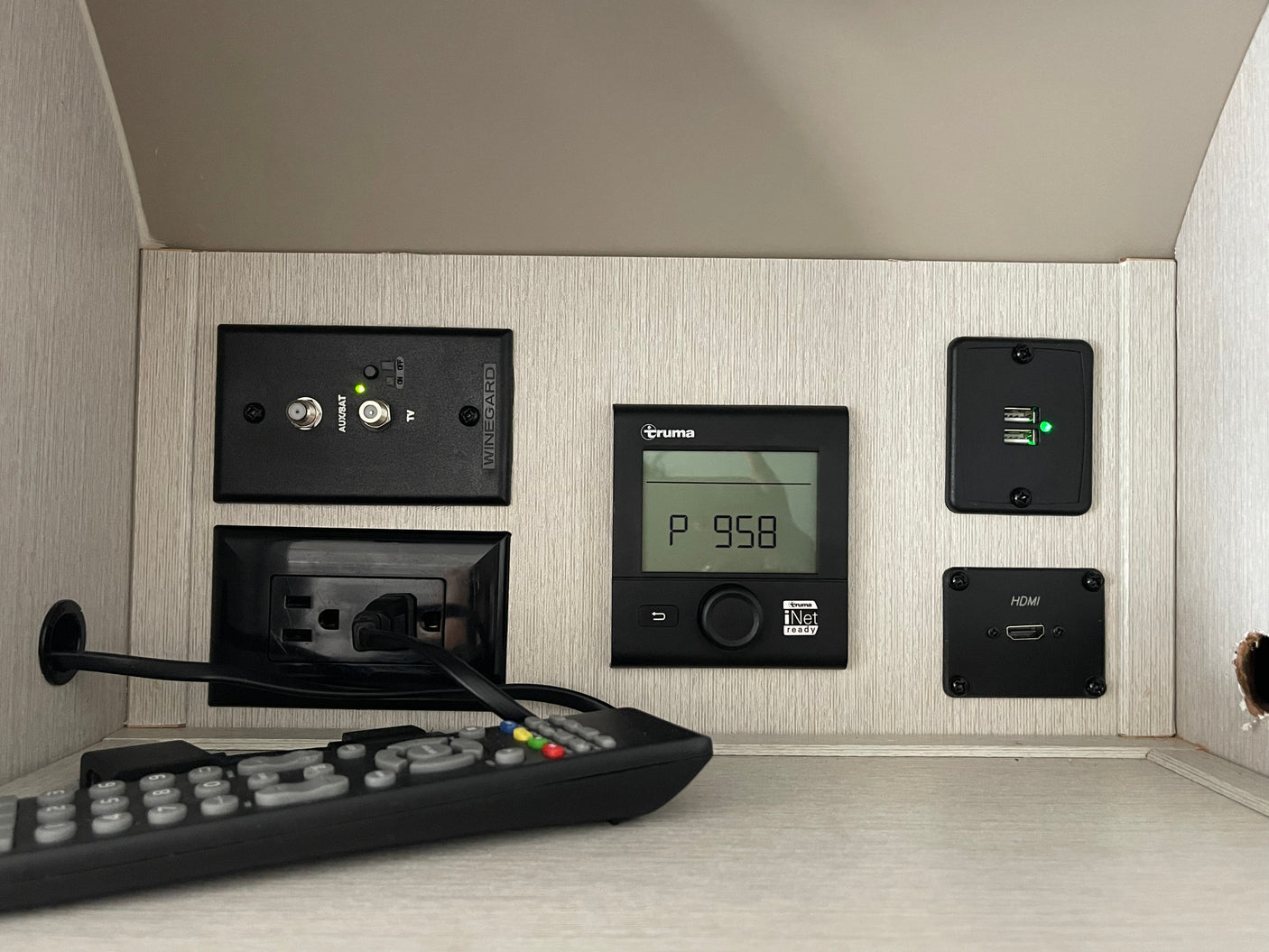 An RV rental's utility panel: Winegard TV, Truma control, USB charging, and HDMI ports for entertainment and convenience.