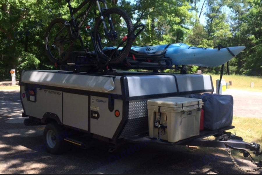 and compact kitchen with stove and sink for comfortable travel.|Enjoy meals in your **rv rental**! This pop-up camper's dining space features blue enamel dishes & a backyard view.|Explore this RV rental's pop-up camper interior
