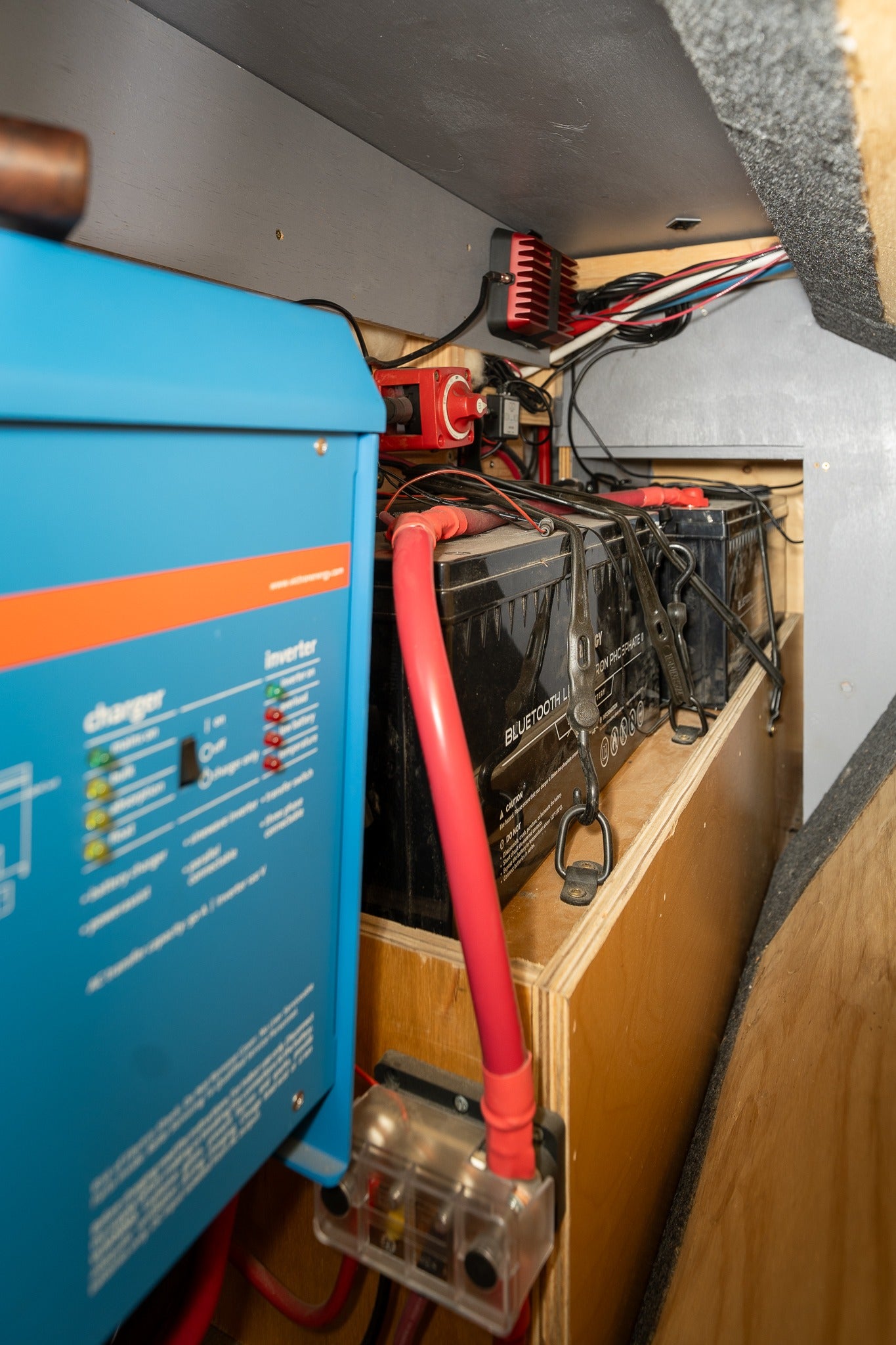 Inside an RV rental: Victron inverter/charger, LiFePO4 batteries, and power wiring for off-grid living.