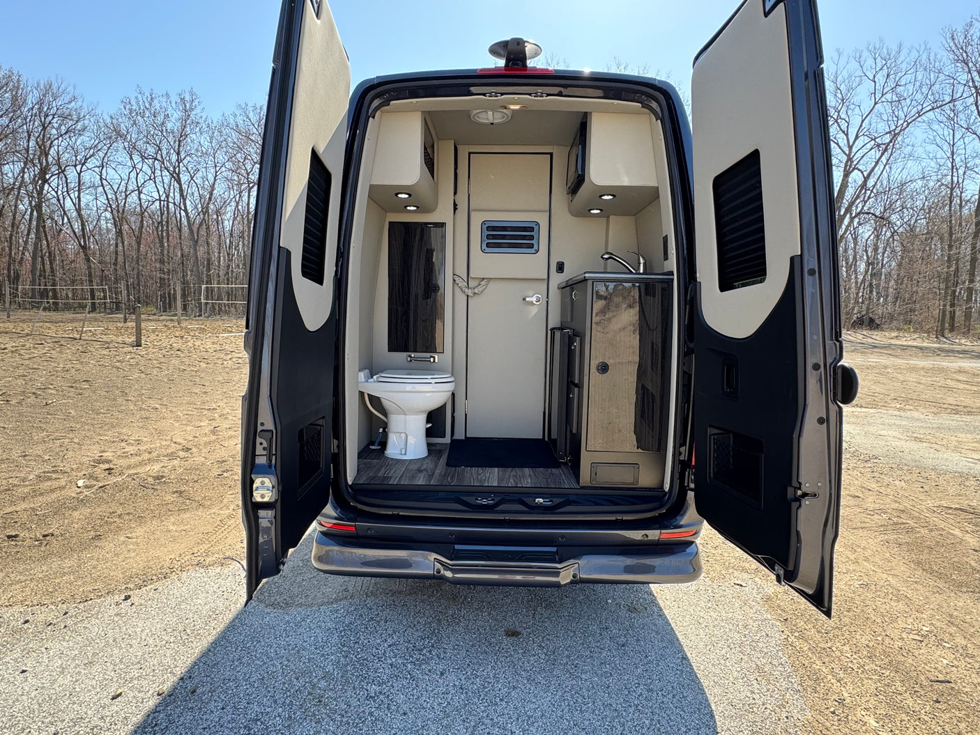 This RV rental showcases a compact interior with a toilet and sink, ideal for mobile living adventures.