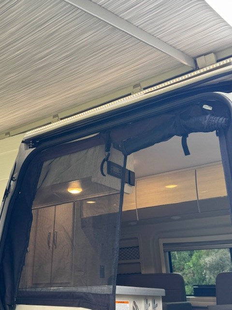 and a stunning view of water and distant hills through the window.|Explore this rv rental's compact kitchen: sink — photo 9