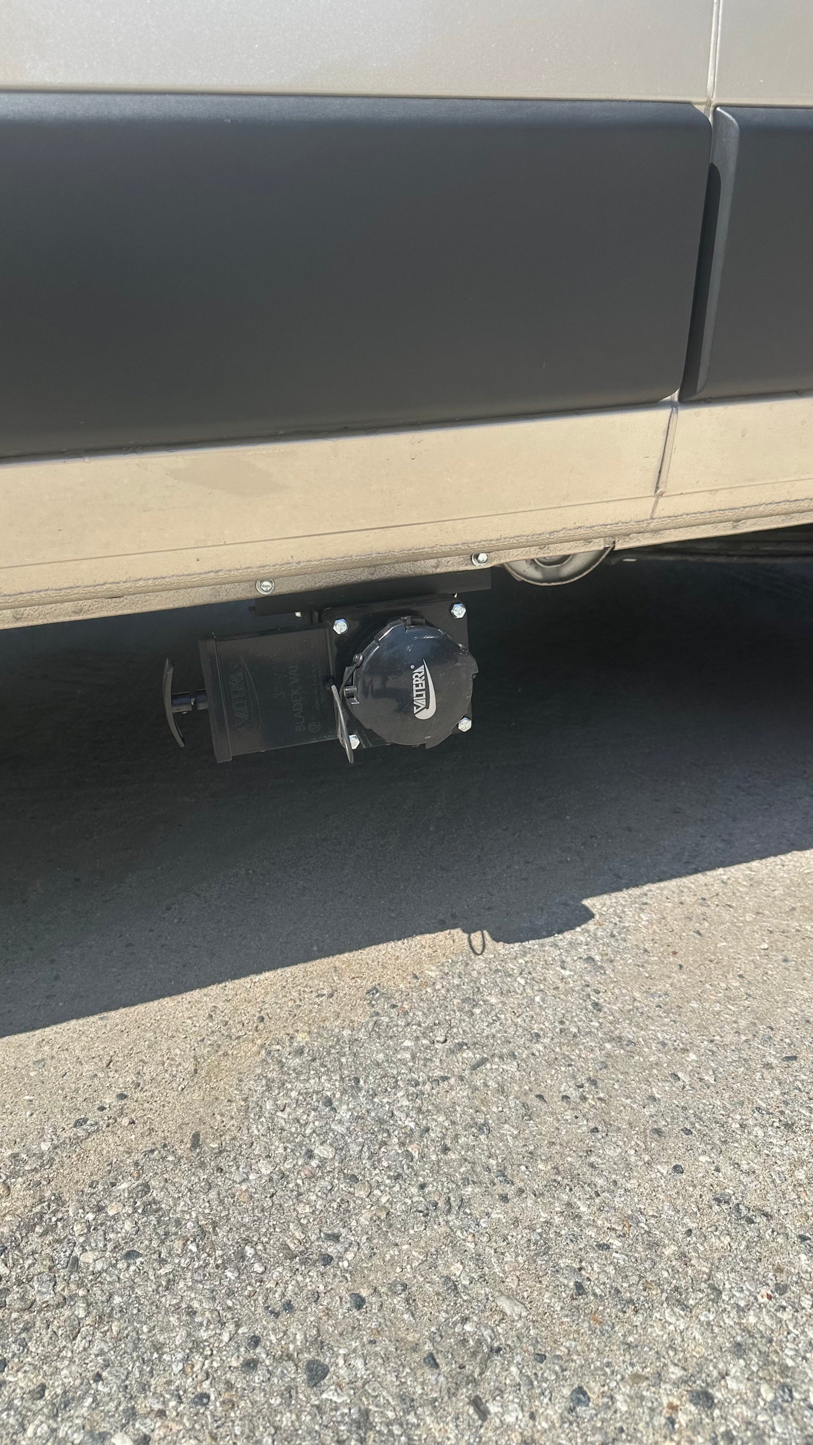 RV rental's undercarriage showing Valterra waste water dump valves, essential for sanitary disposal.