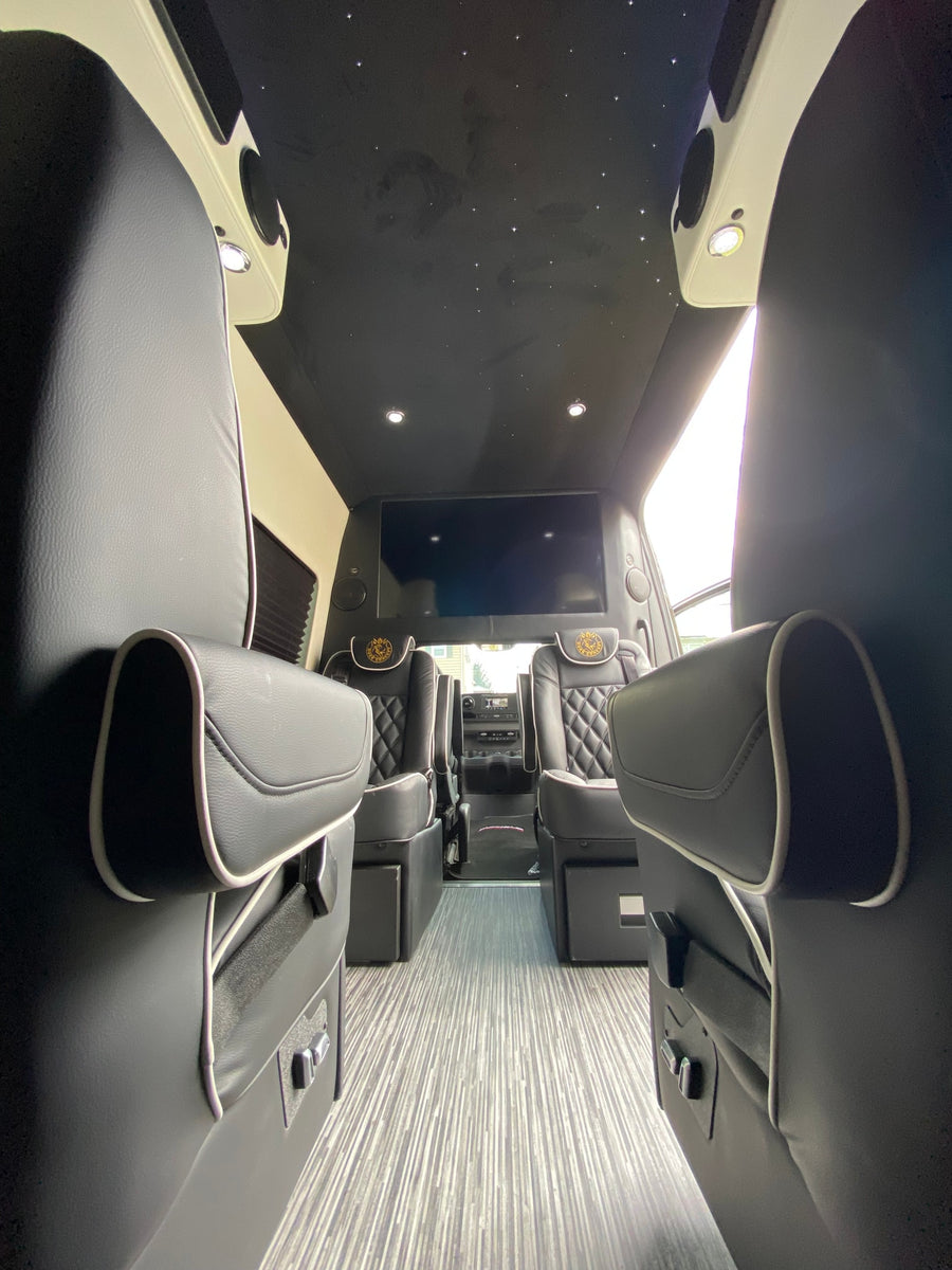 Explore this luxury RV rental's interior: plush seating, large entertainment screen, and starlight ceiling. Perfect for comfortable journeys.