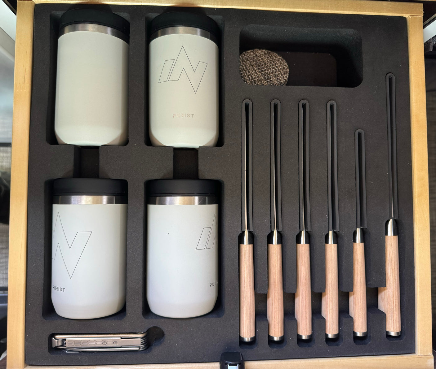 RV rental picnic set: White Purist tumblers, wood-handled knives, and a multi-tool, neatly organized in a custom foam-lined wooden box.