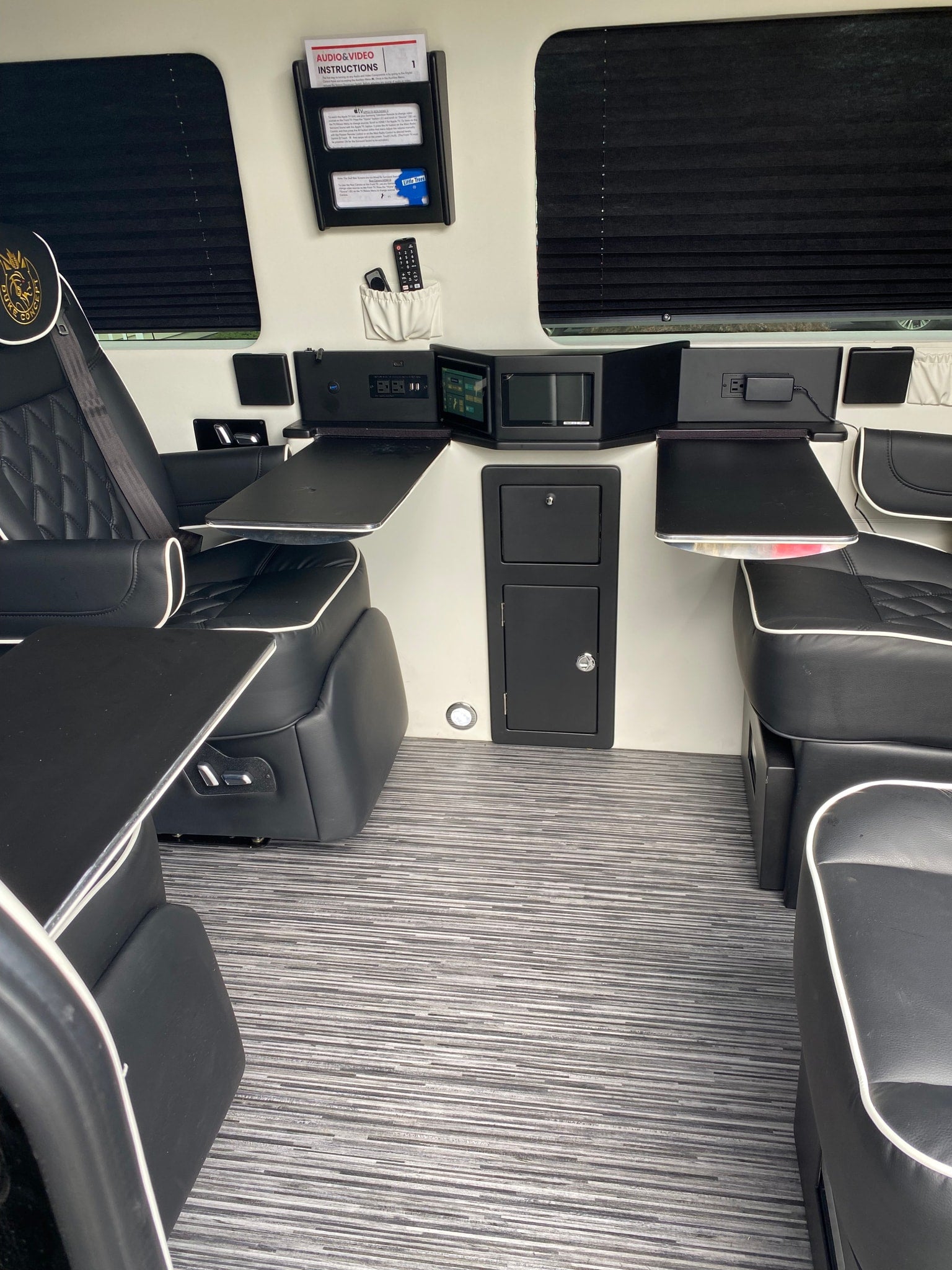 Custom luxury RV rental interior: ergonomic seating, entertainment system, and work tables for travel.
