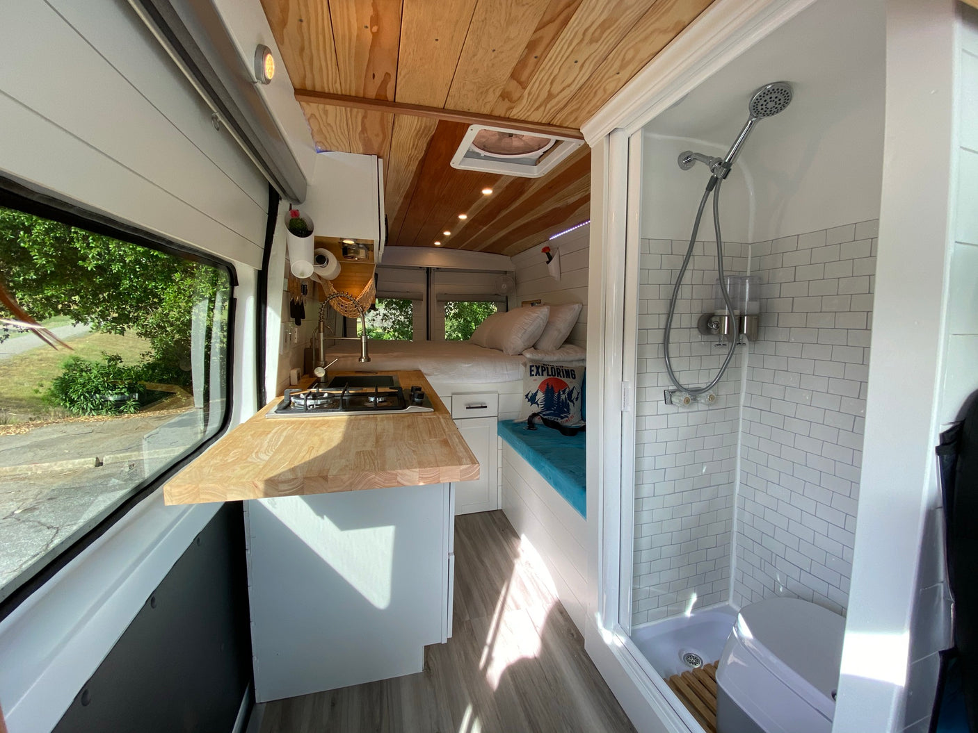 Explore this stylish RV rental's interior: well-equipped kitchen, comfortable bed, and a compact shower/toilet.