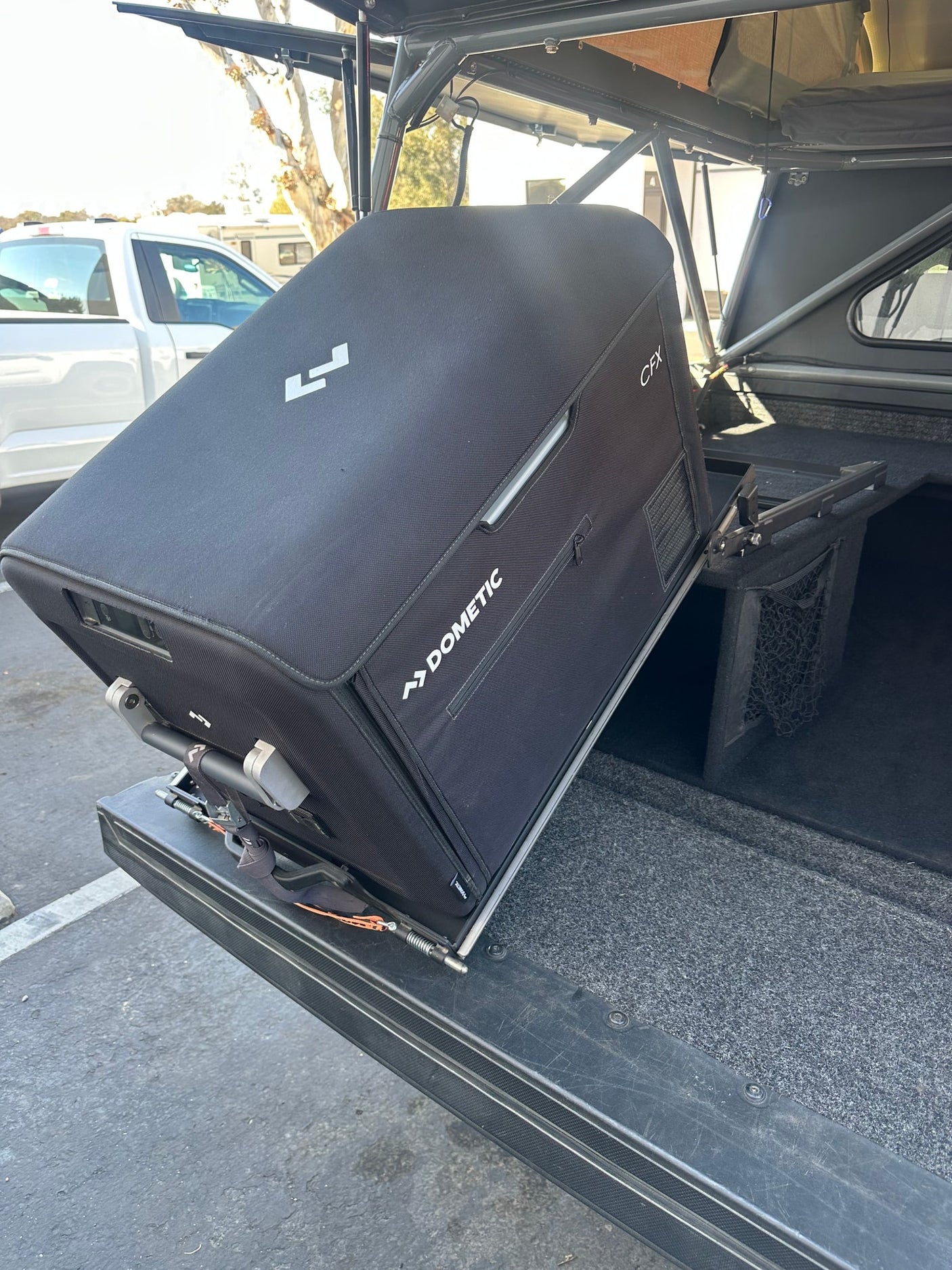 Dometic CFX portable fridge on a slide-out in a truck camper, ready for an RV rental outdoor adventure.