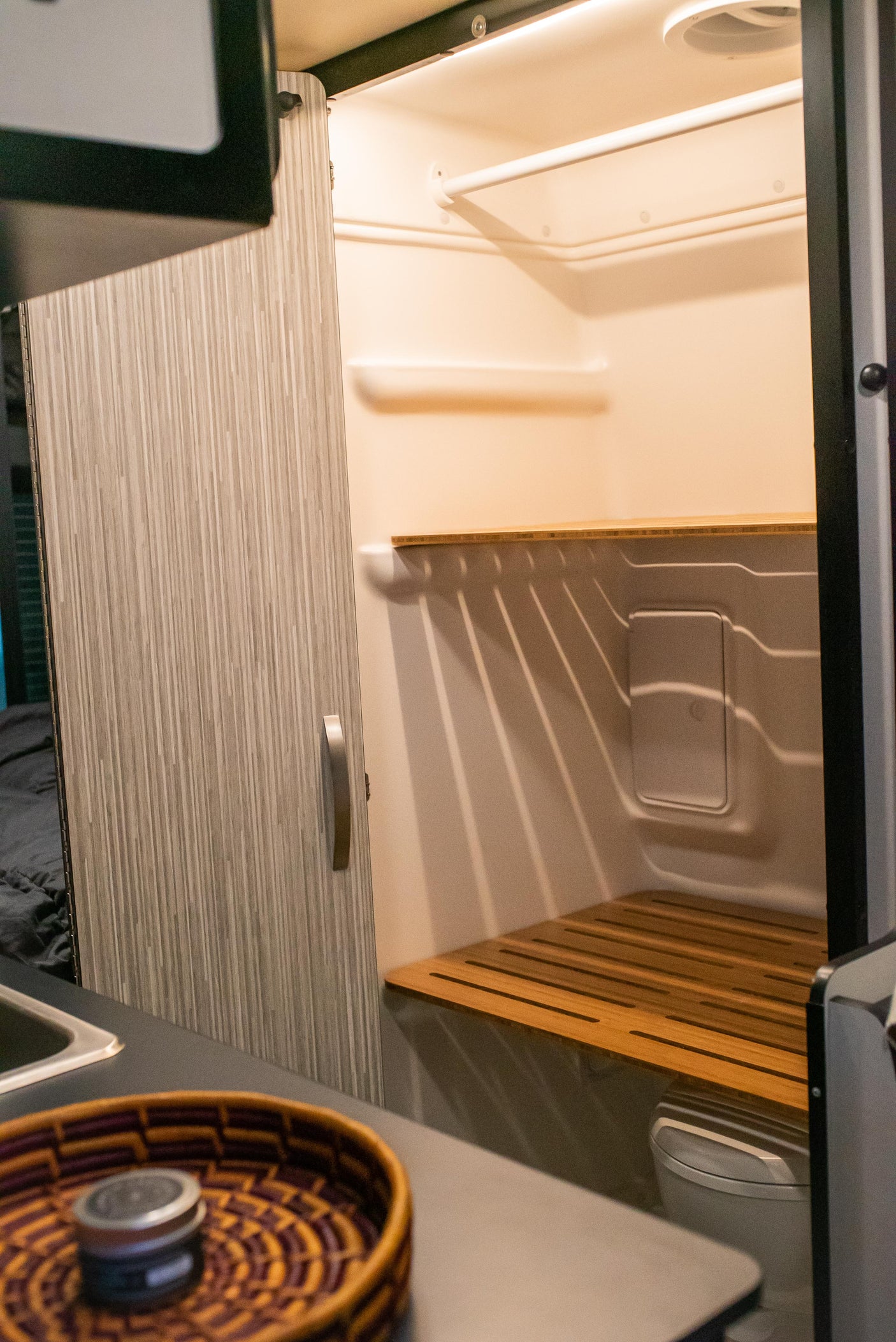 RV rental interior: A compact, modern wet bath featuring a shower, toilet, and sink area for comfortable travel.