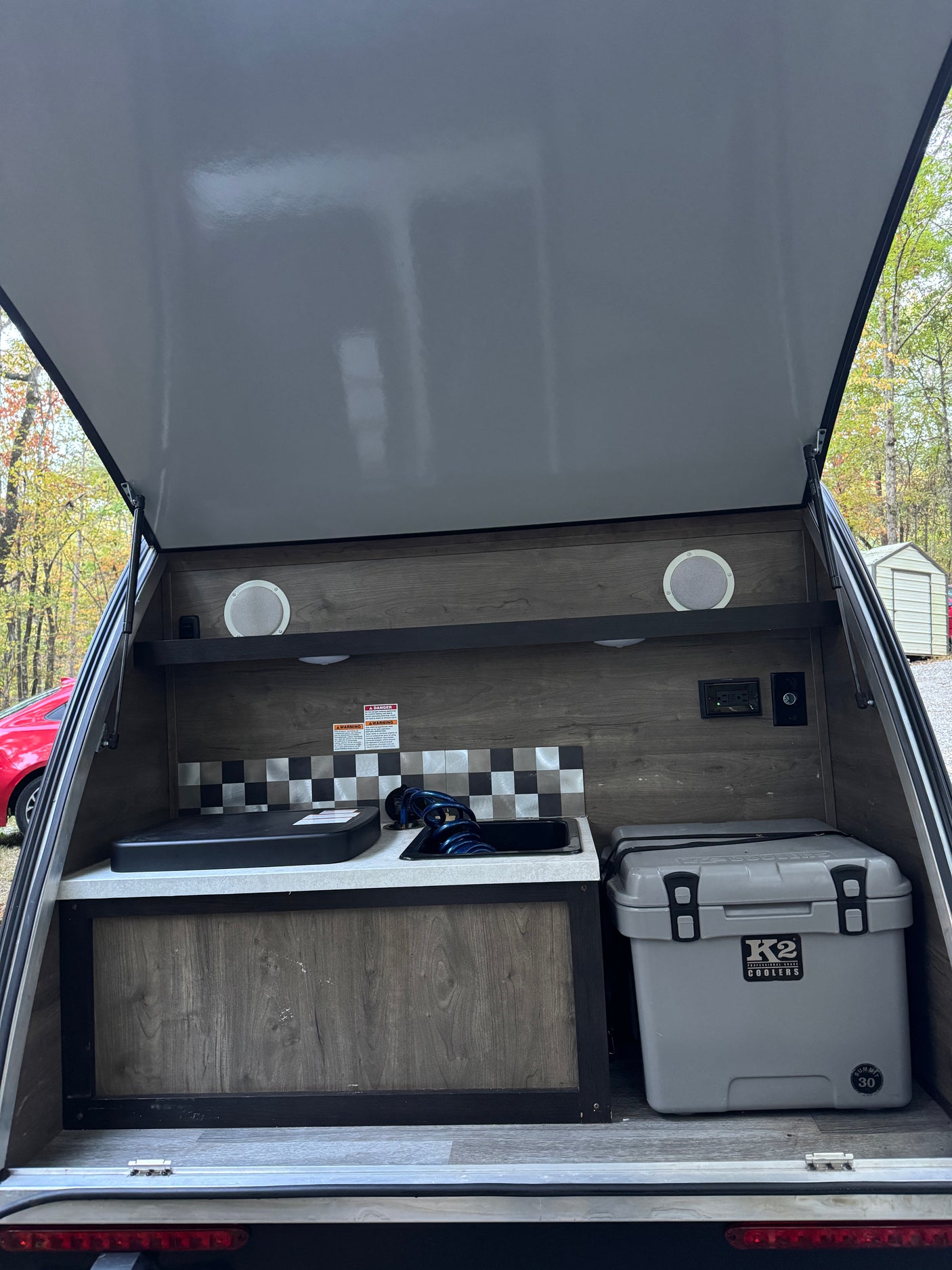 Teardrop RV rental: Open galley with sink, counter, K2 cooler. Ready for outdoor cooking & camping adventures!