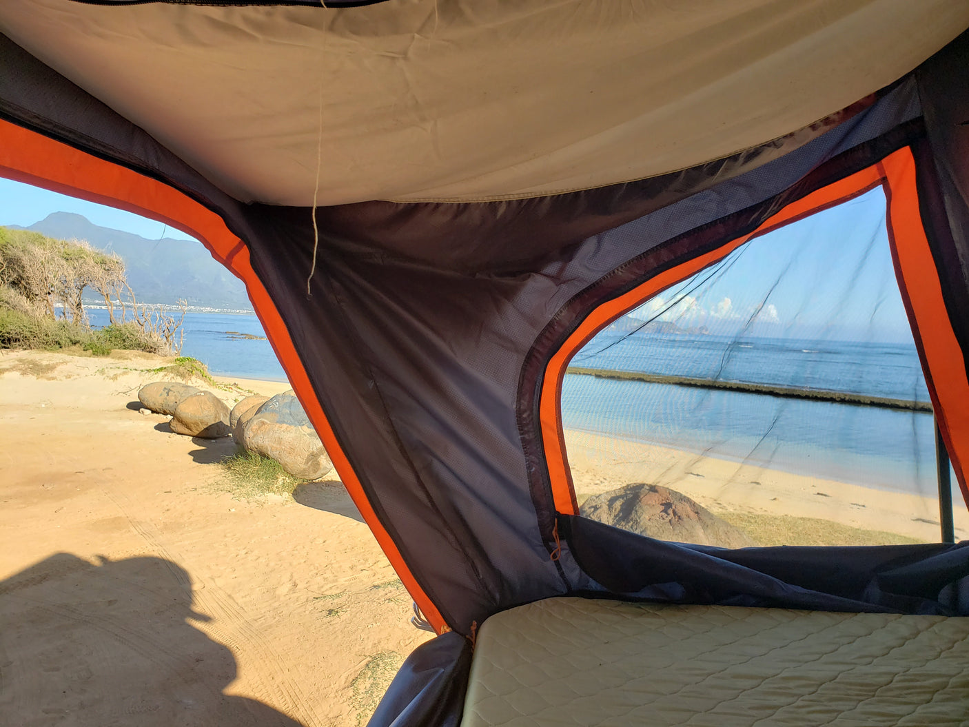 Enjoying a stunning beach and ocean view from inside an RV rental tent, perfect for coastal camping.