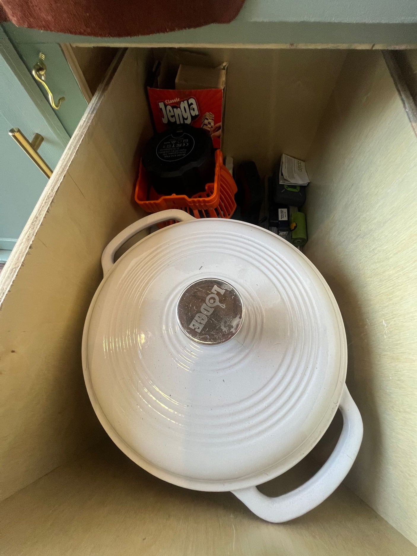and various kitchen towels. Essential compact storage.|RV rental kitchen drawer neatly stores nested cast iron skillets and a red trivet on patterned liner. Ideal compact cooking.|Empty mini-fridge interior in an RV rental