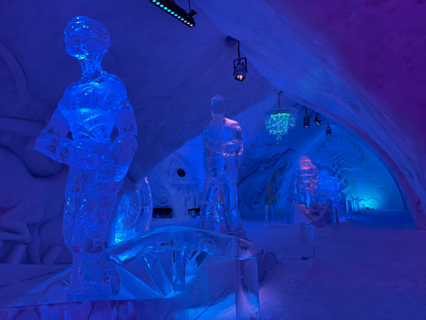 Vivid blue & purple lit ice art gallery with human sculptures. A unique rv rental destination experience.