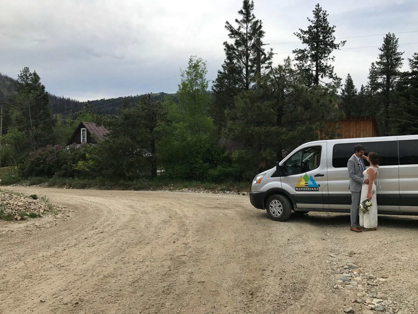 Bride & groom by their WANDERVANS **RV rental** van on a scenic mountain road. Perfect for an adventurous wedding!