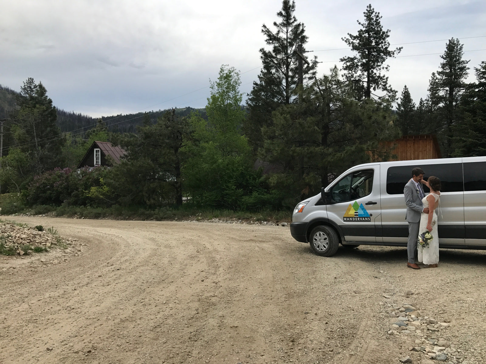 Bride & groom by their WANDERVANS **RV rental** van on a scenic mountain road. Perfect for an adventurous wedding!
