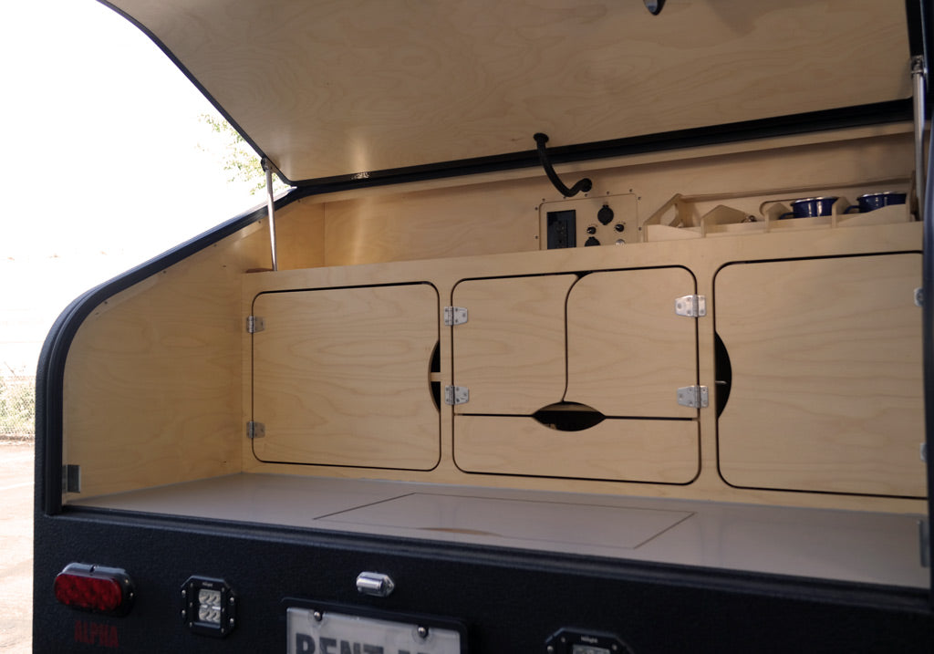 with a dark floor and blurred interior details.|RV rental interior panel: volt meter