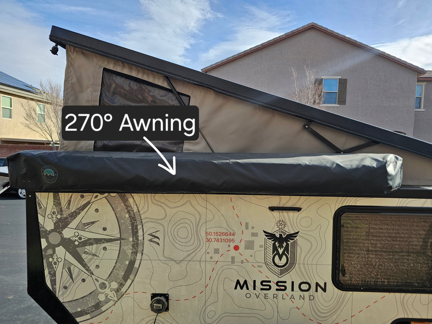 This Mission Overland camper trailer RV rental features a 270° awning and distinctive topographic map graphics on its side.