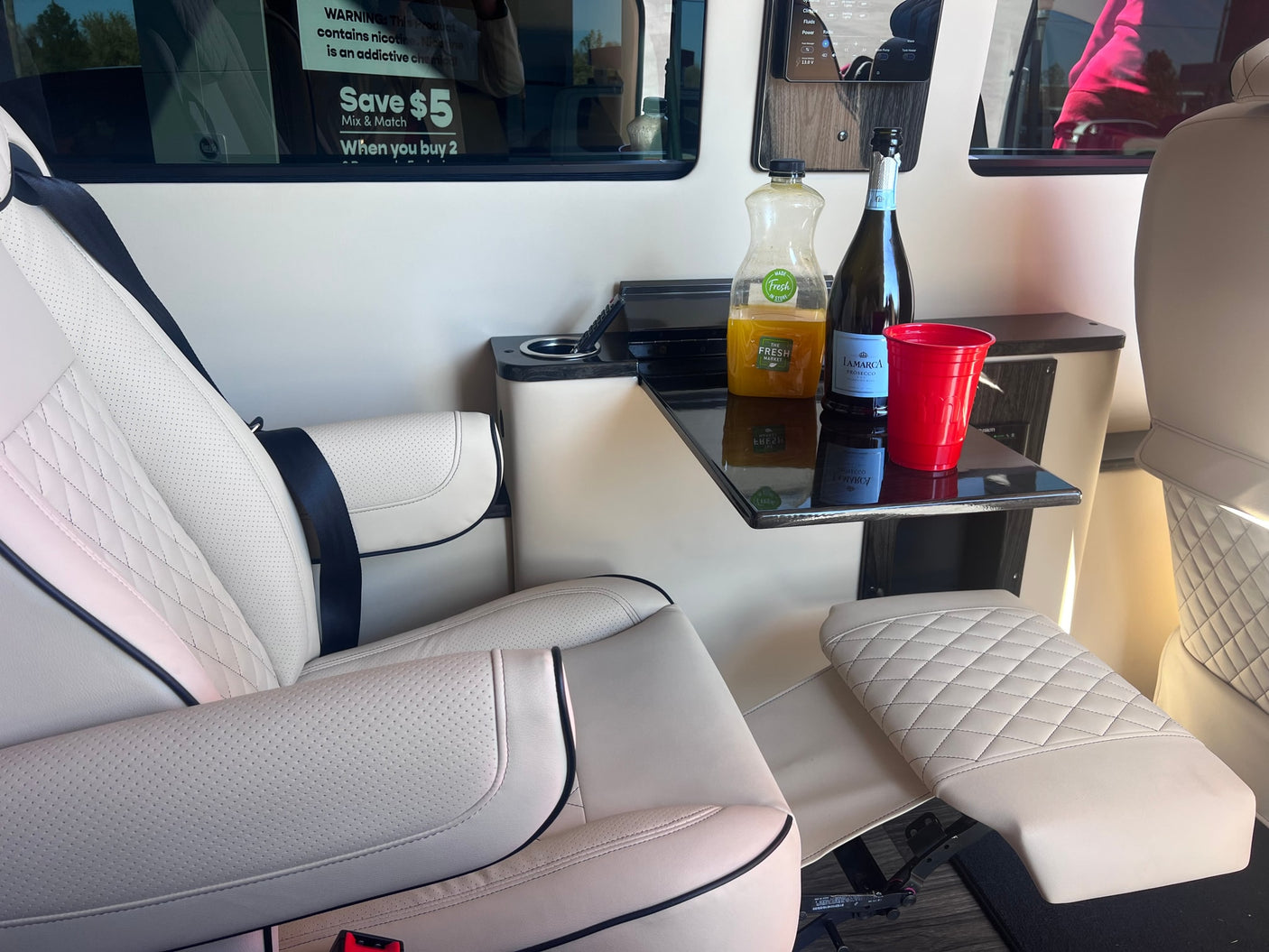 and protected seats.|Spacious RV rental interior: view of driver's cabin with cream-colored luxury seats