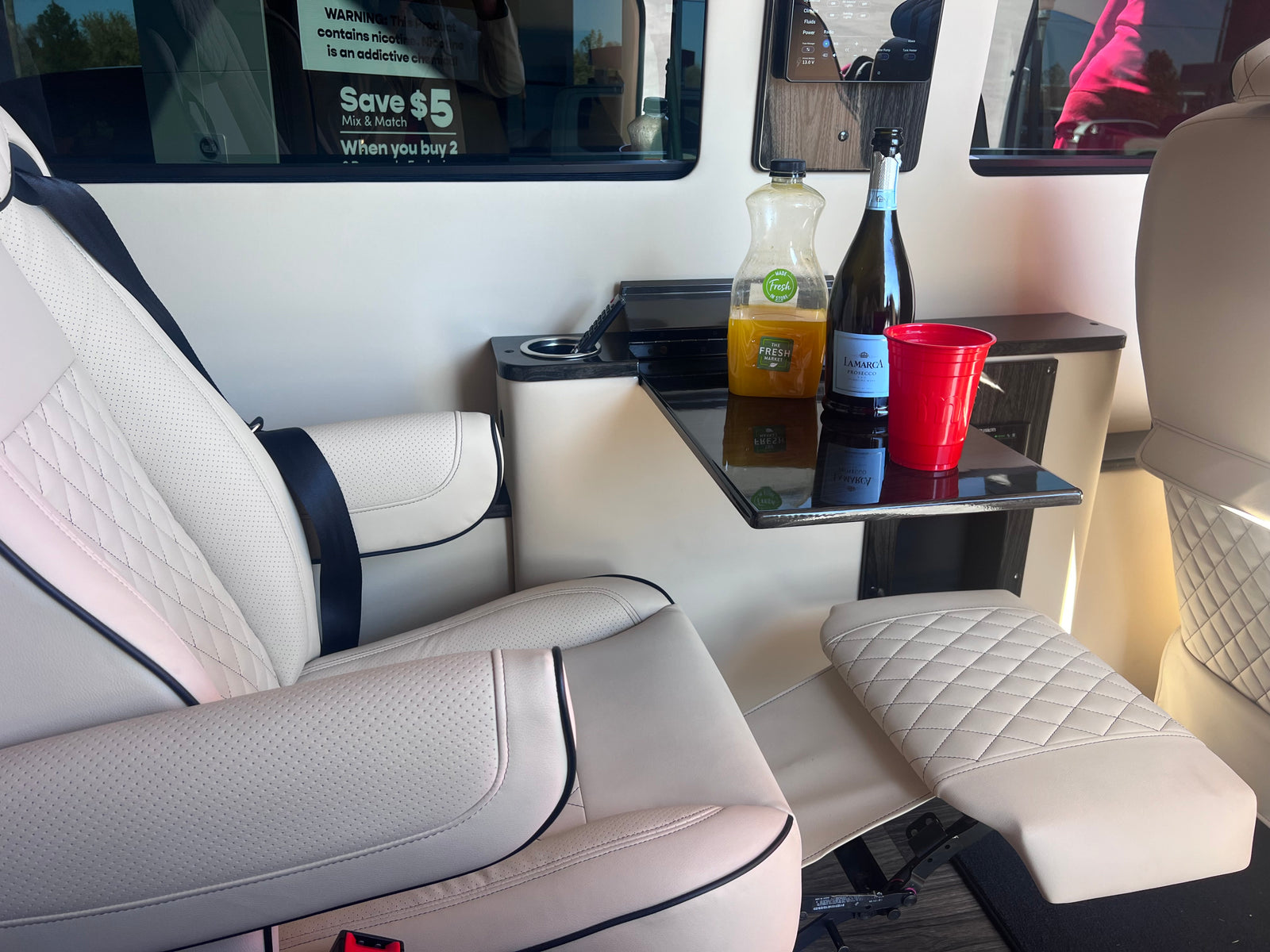 and protected seats.|Spacious RV rental interior: view of driver's cabin with cream-colored luxury seats