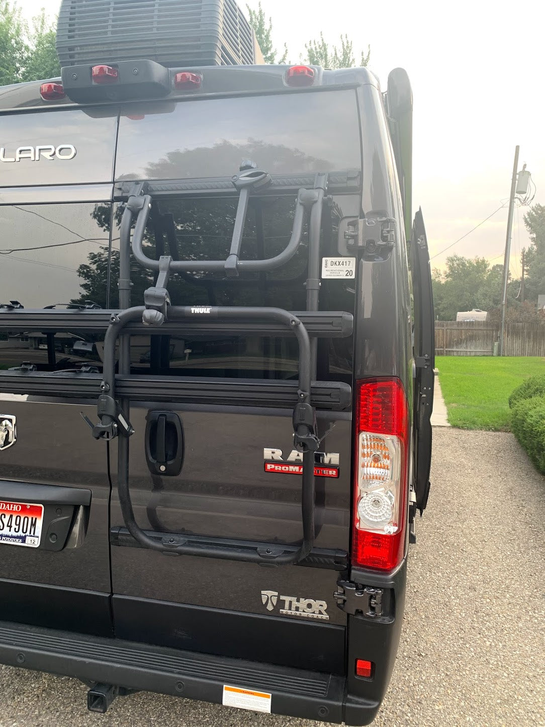Back of a dark gray Ram ProMaster RV rental, featuring a Thule bike rack for your next adventure.