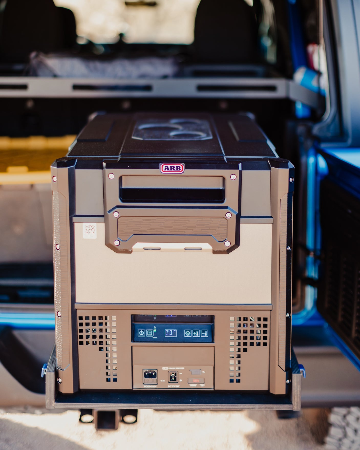 An ARB fridge freezer, seen on a slide-out tray, is a vital accessory for any RV rental or off-road camping trip.