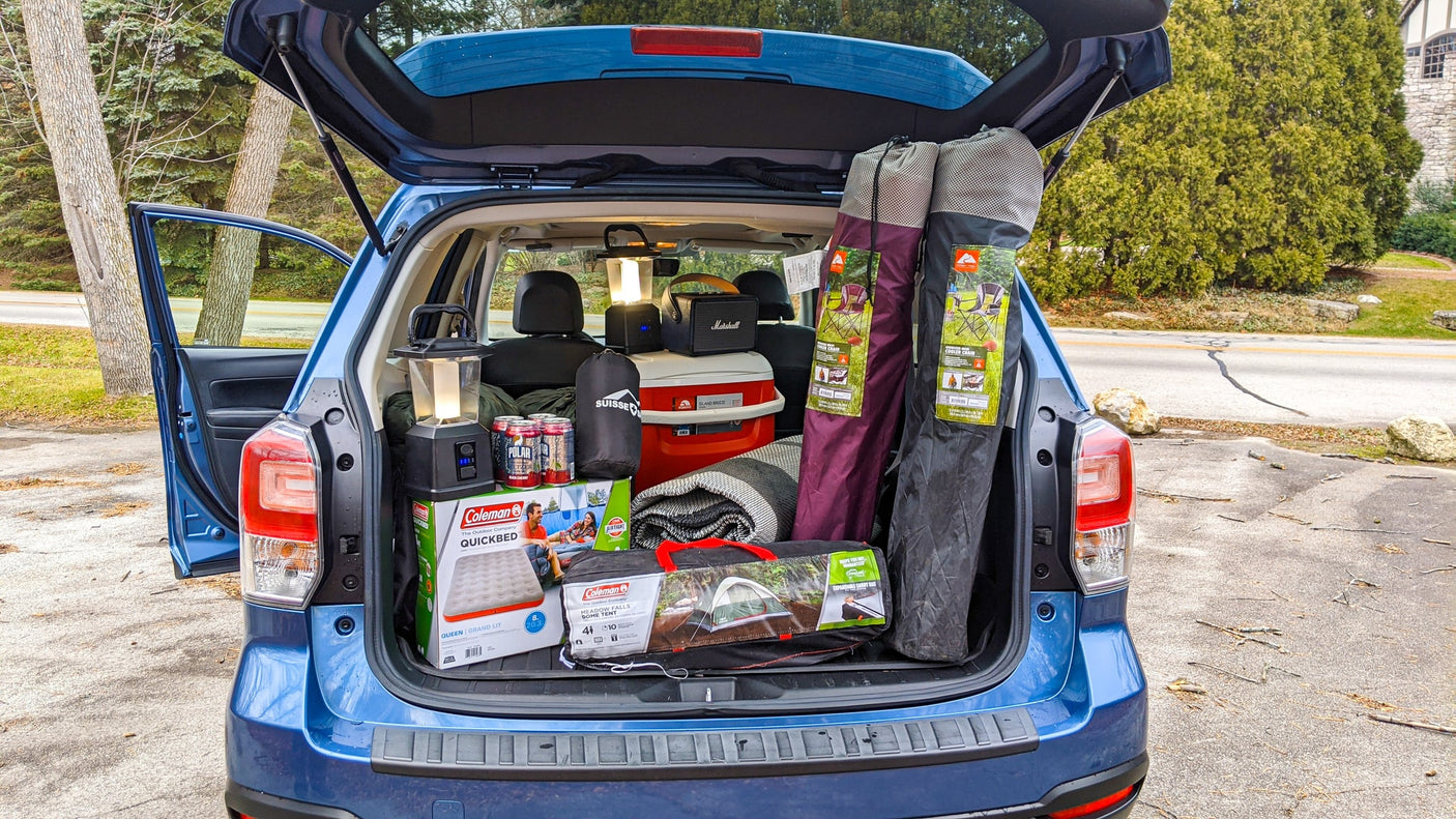 Car trunk full of camping gear: Coleman tent, cooler, lanterns, and chairs. Ready for adventure or your RV rental trip!
