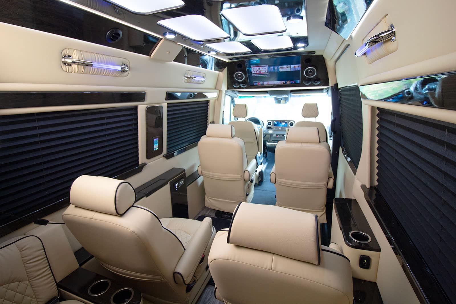 and ambient lighting for a premium travel experience.|Spacious luxury RV rental interior. Plush cream seating