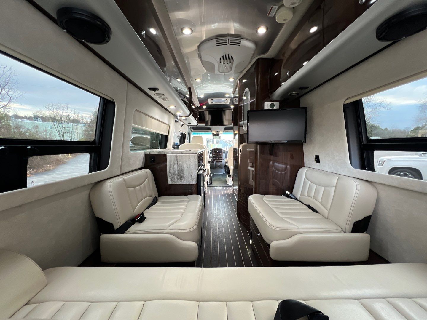 ideal for travel adventures.|Spacious luxury RV rental interior features cream leather seating