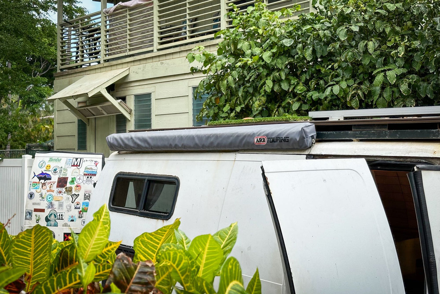Close-up of an rv rental camper van featuring an ARB awning, roof rack, and stickers. Ready for your next travel adventure!