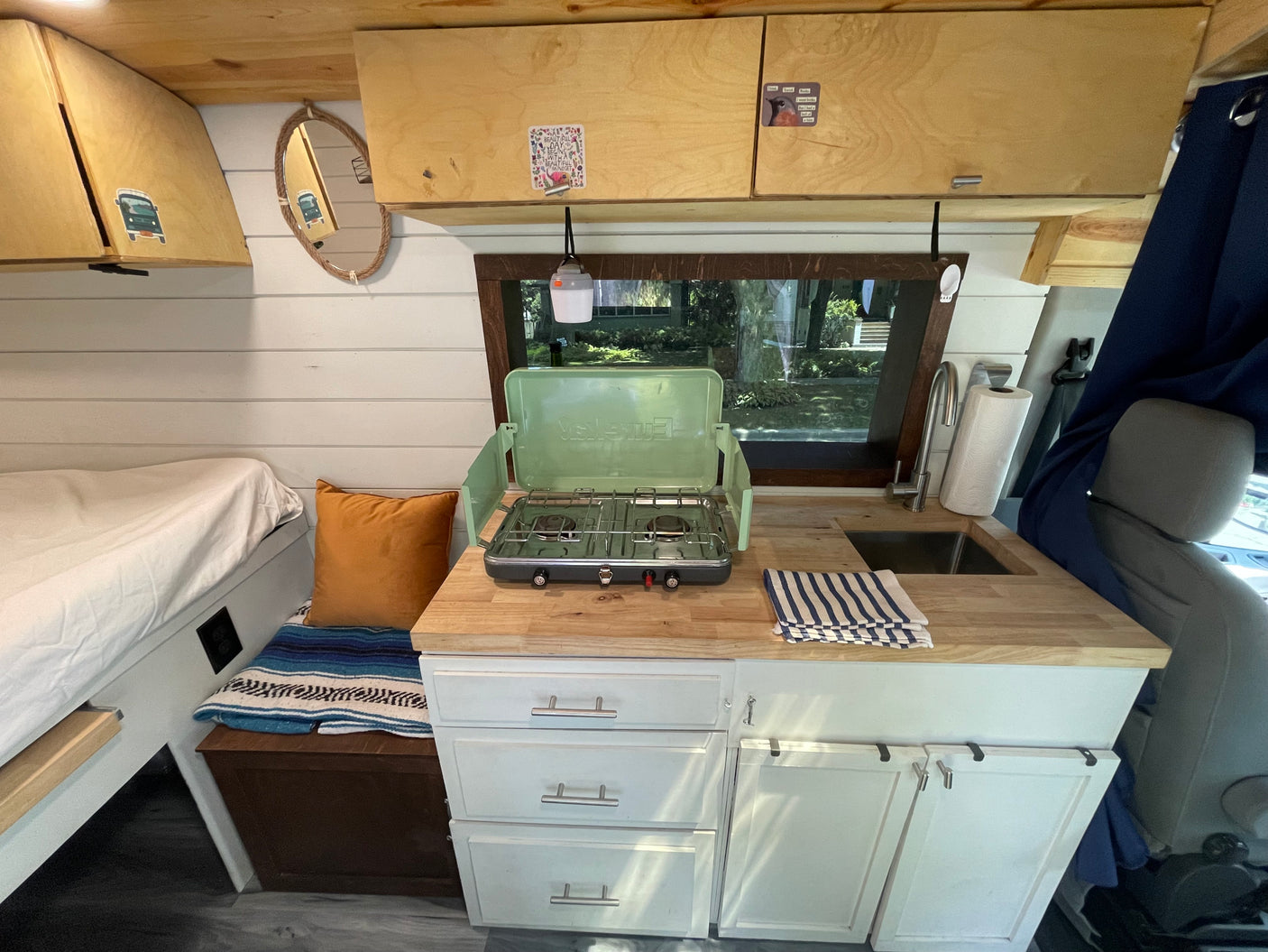 This cozy RV rental features a camper van interior with a well-equipped kitchenette, bed, and storage space.