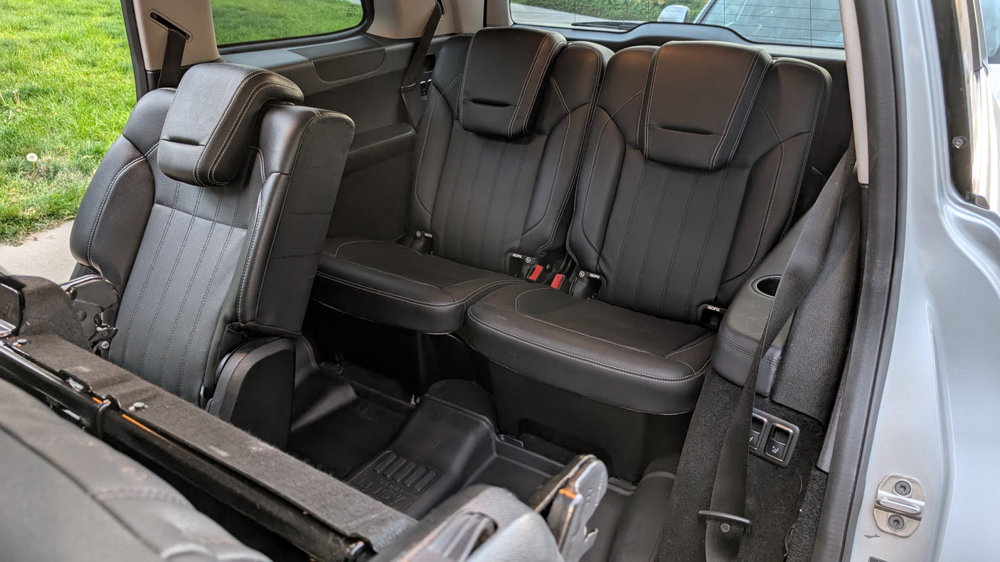 Interior of an RV rental: spacious black leather second and third-row seats, ideal for comfortable travel.