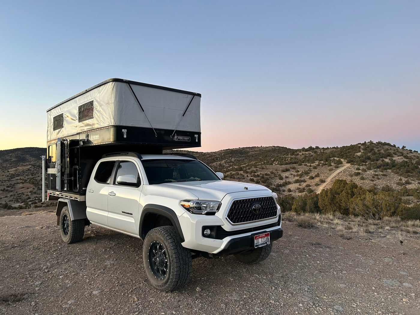 White Toyota Tacoma with Four Wheel Pop-Up Camper — photo 1