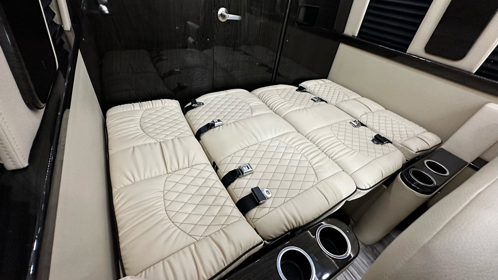 RV rental interior with plush, quilted seating converted to a bed, showing comfort and utility.