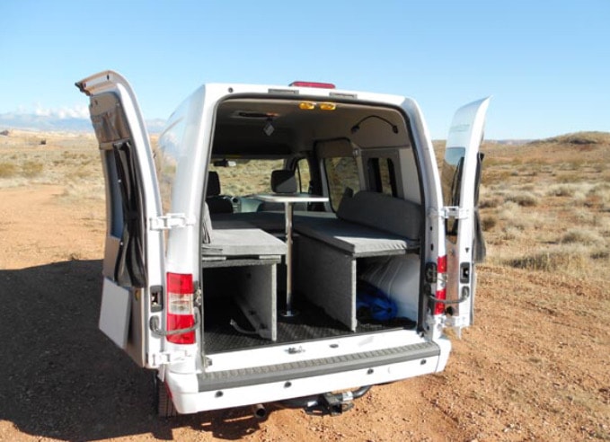 enjoying scenic mountain views from a camper van. Ideal for outdoor enthusiasts.|White camper van RV rental with open back