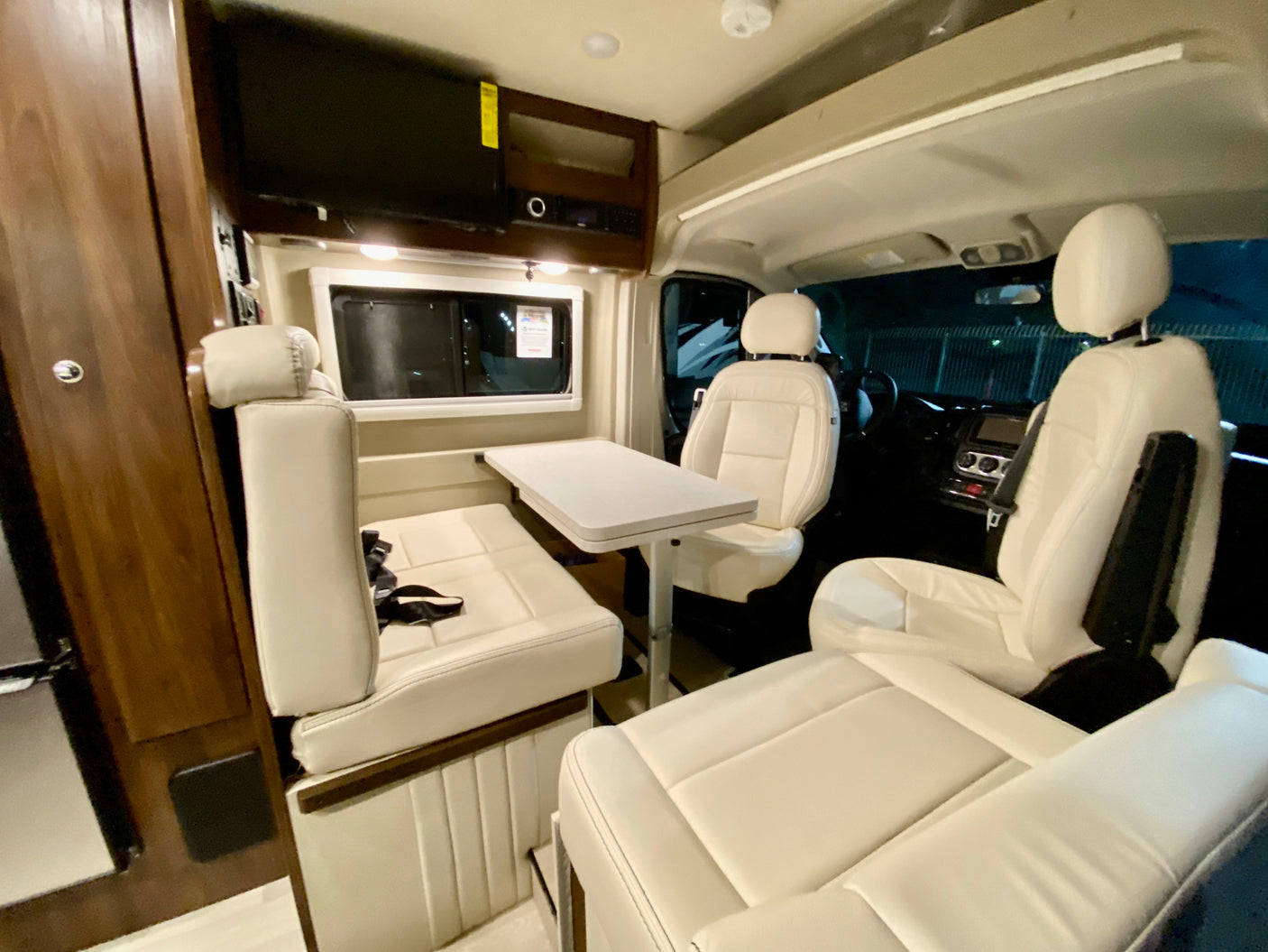 Spacious RV rental interior with cream seating, dinette, and TV, perfect for comfortable road trips.