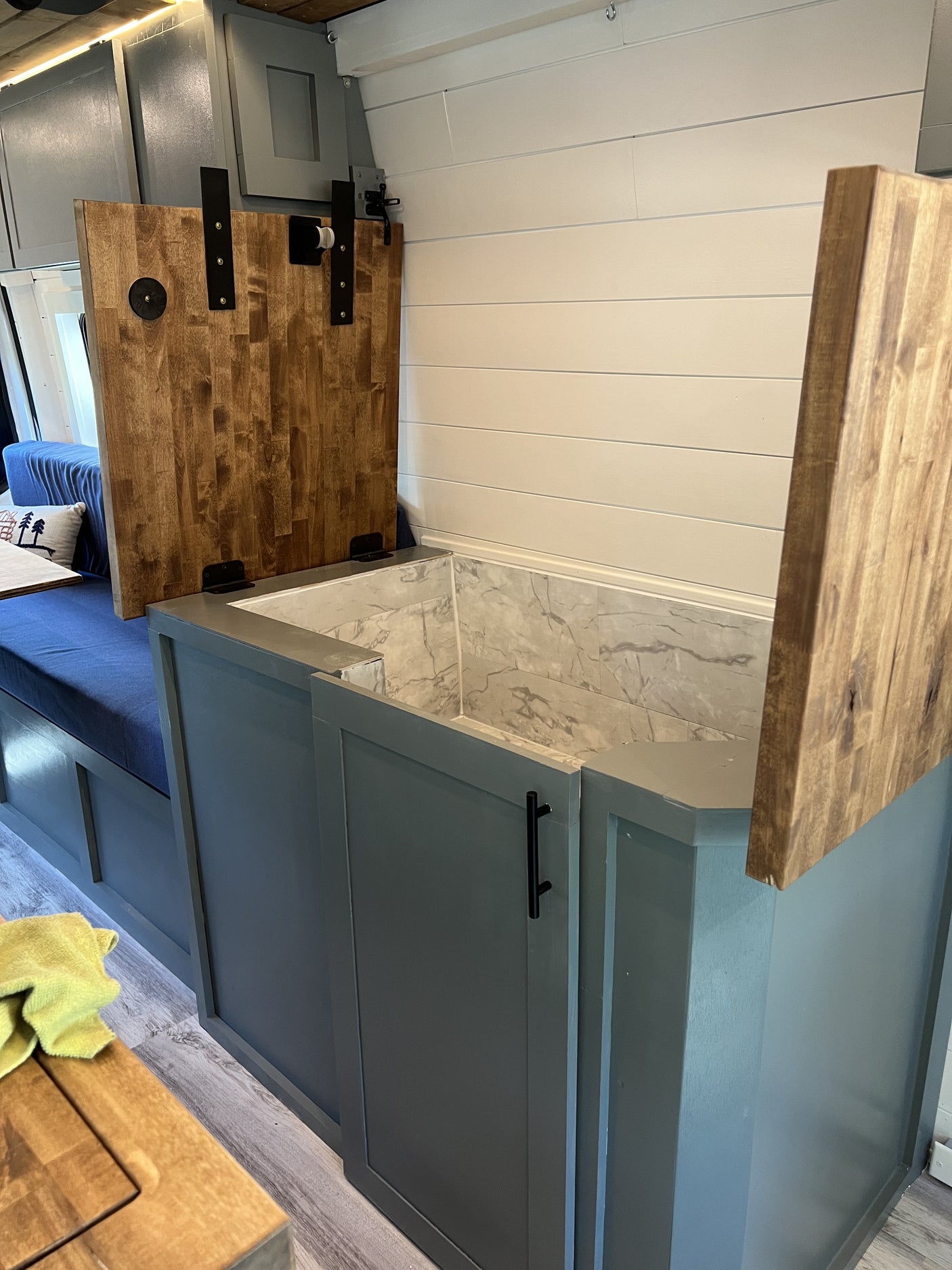 with green view outside.|Bright and modern RV rental interior featuring a full kitchen with wood counters