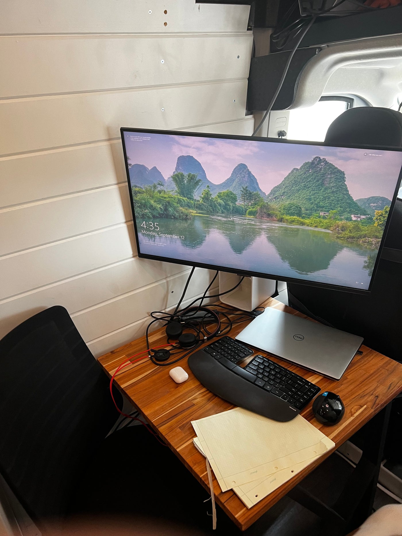 Productive workspace in an RV rental: Monitor, Dell laptop, ergonomic keyboard, & accessories on wood desk. — photo 4