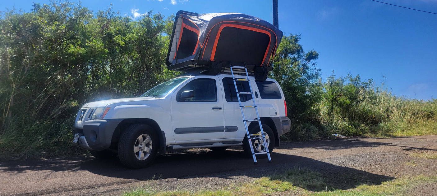 A white SUV with an open rooftop tent and ladder, ideal for an RV rental outdoor adventure.