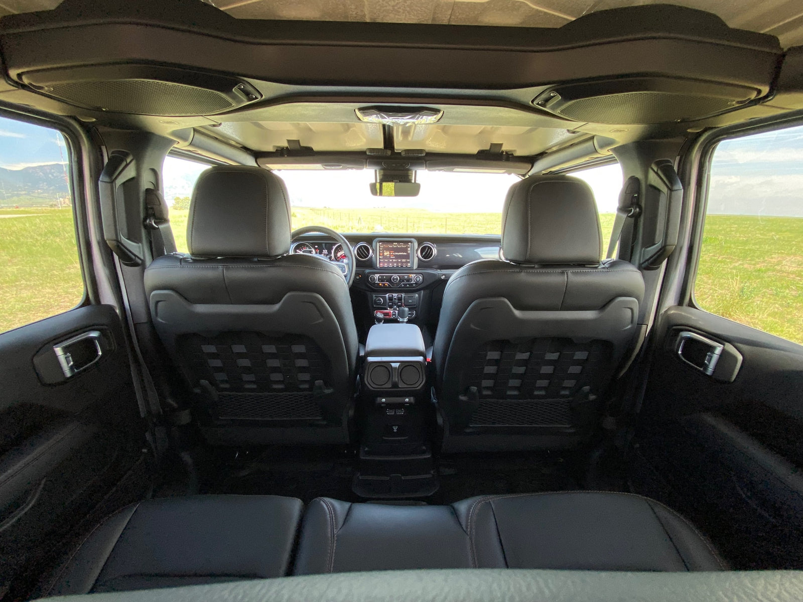 Spacious adventure vehicle interior, great for an rv rental road trip. View from rear seats toward dashboard & scenery.