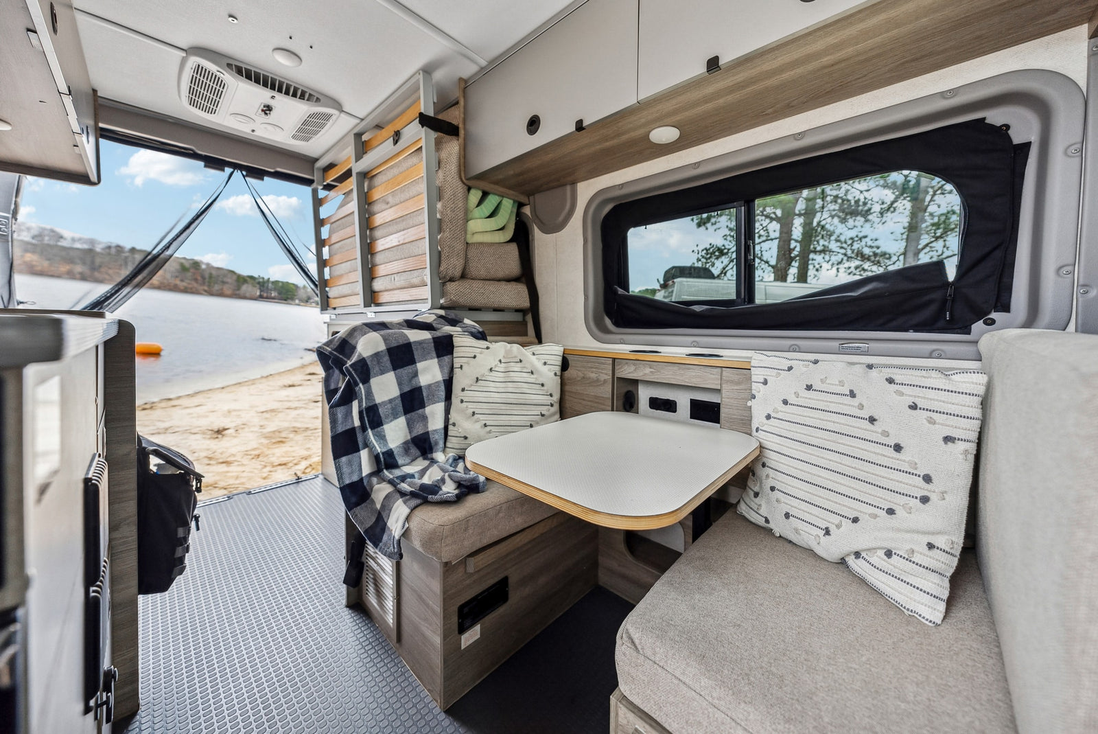 wooded campsite with a picnic table.|Inside a versatile RV rental