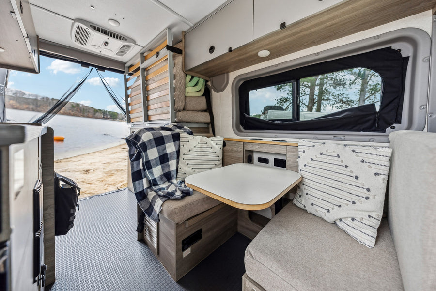 wooded campsite with a picnic table.|Inside a versatile RV rental