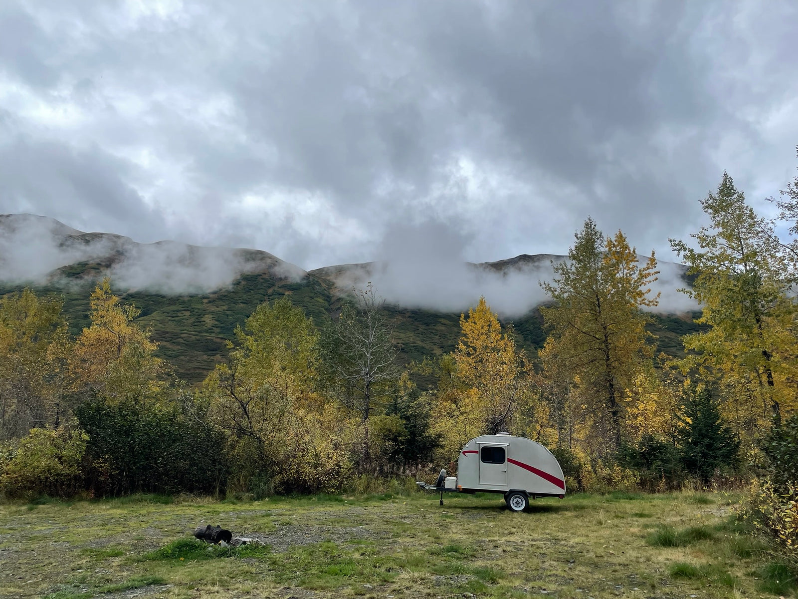 Teardrop RV rental among golden autumn trees